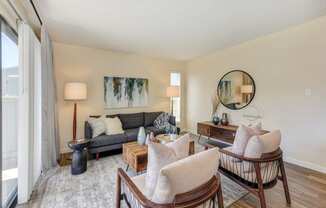 Living room with two tone paint,  Hardwood Inspired Floor, Gray/White Rug, Gray Sofa and Round Mirror  at Silverstone Apartments, Davis, CA