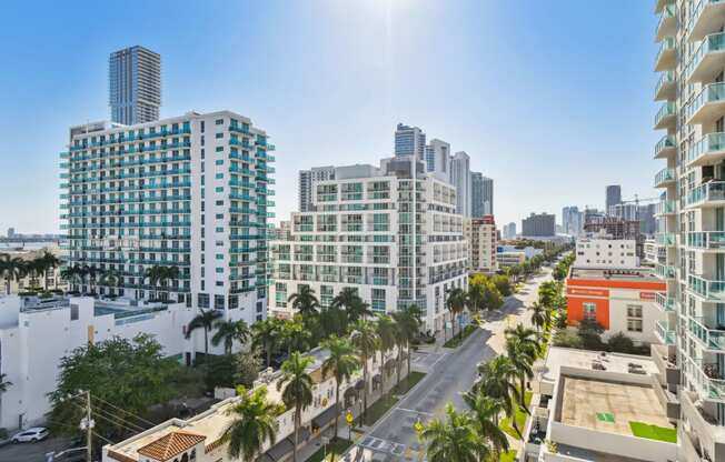 an aerial view of a city street with tall buildings and palm trees