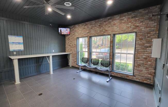 an empty room with a table and chairs and a brick wall