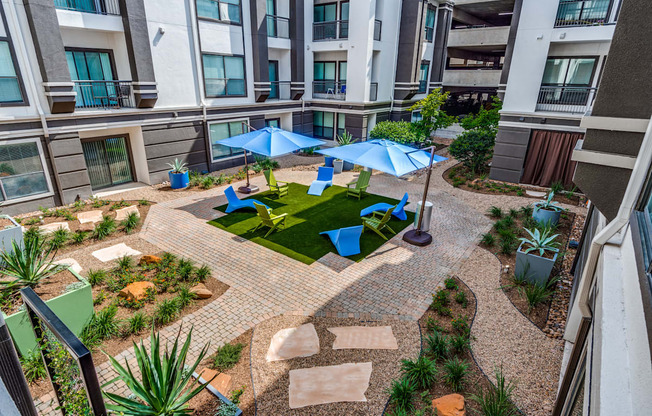 an outdoor area with umbrellas and chairs in an apartment building