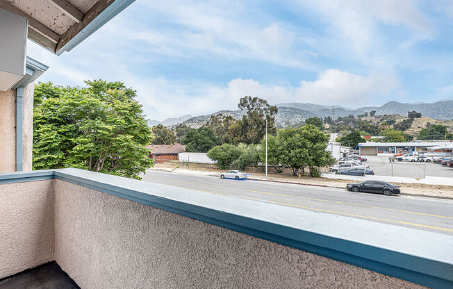 Private balcony with view of tree-lined surrounding community.