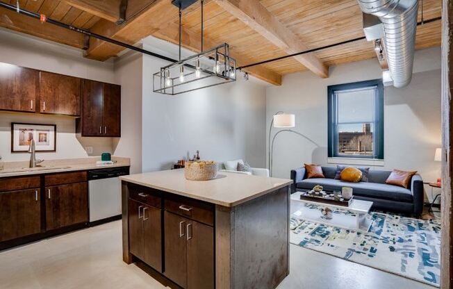 Lofts open living area with exposed beams and ducts