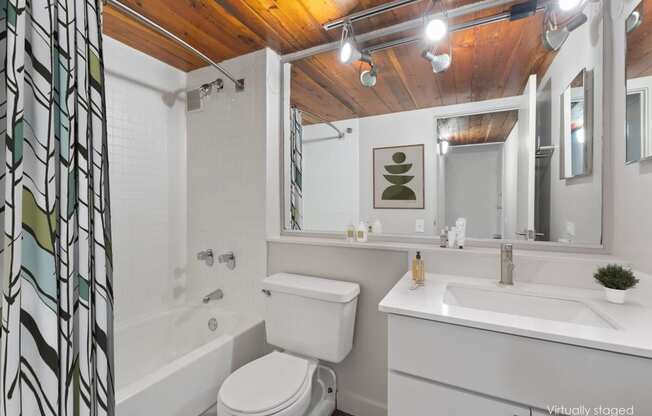 a bathroom with a toilet sink and a tub and a mirror