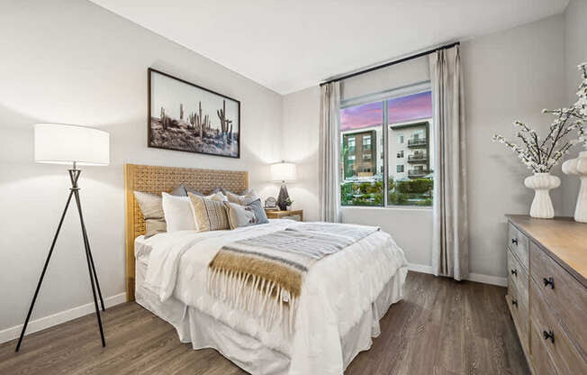 Model Bedroom with Wood-Style Flooring and Window View at Glen 91 Apartments located in Glendale, AZ.