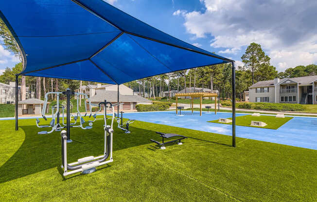 A blue shaded outdoor fitness area with a bench and weights.
