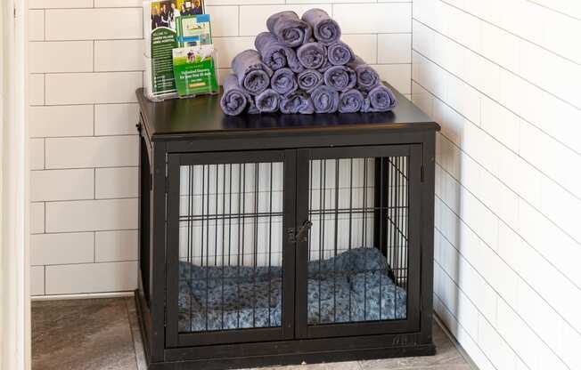a dog cage with purple blankets on top of it