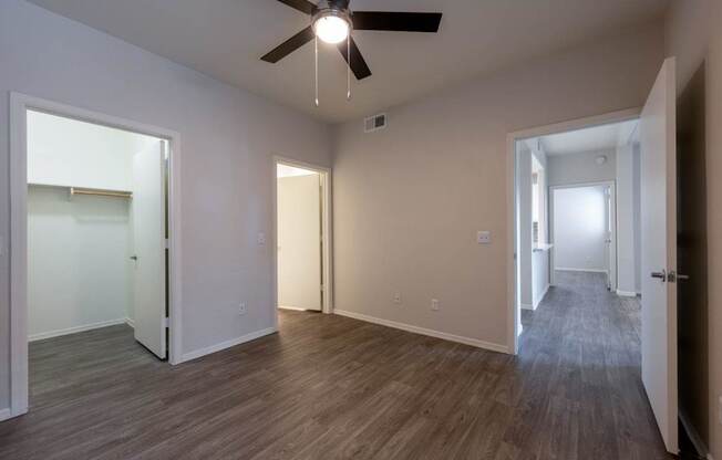 A room with a ceiling fan and wooden flooring.