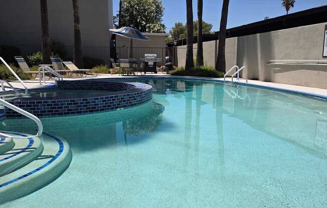 A pool with a blue tiled edge and a metal ladder.