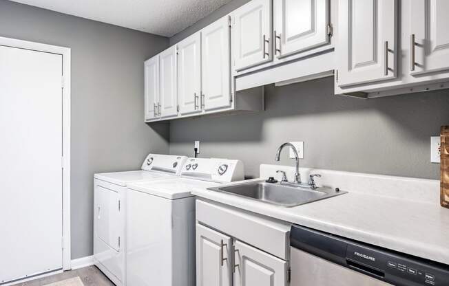 a white kitchen with white cabinets and a sink