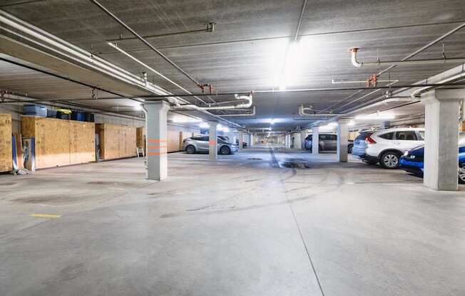 A parking garage with concrete floors and multiple cars parked.