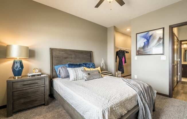 Bedroom with ceiling fan, walk-in closet and master bath at 360 at Jordan West best new apartments West Des Moines IA 50266