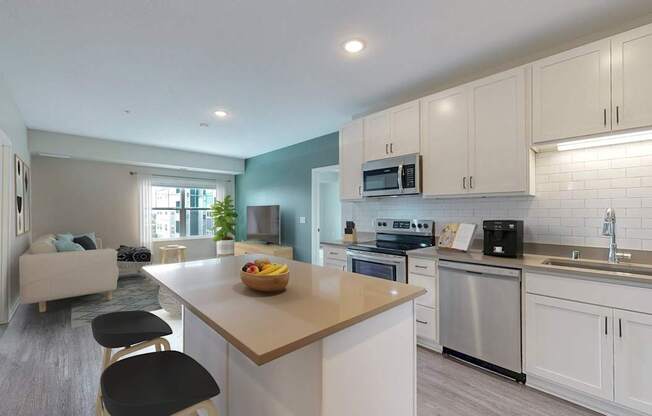 A kitchen with white cabinets and a wooden island.