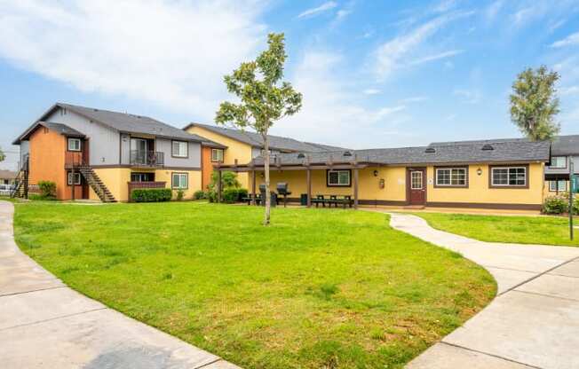 A row of houses with a green lawn in front.