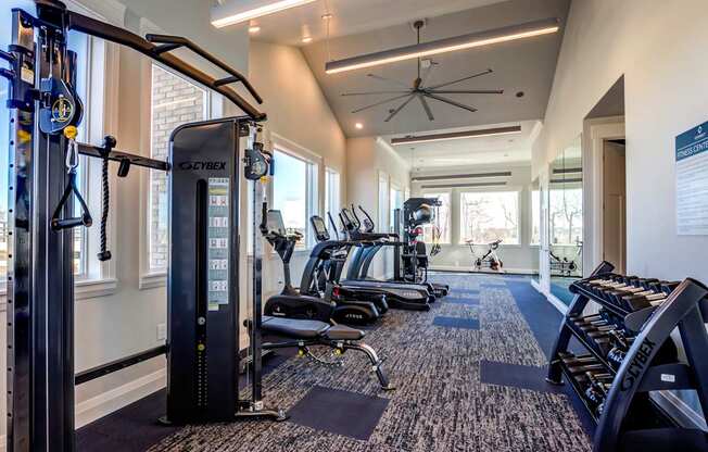 A gym with a variety of equipment including treadmills, stationary bikes, and weight machines.