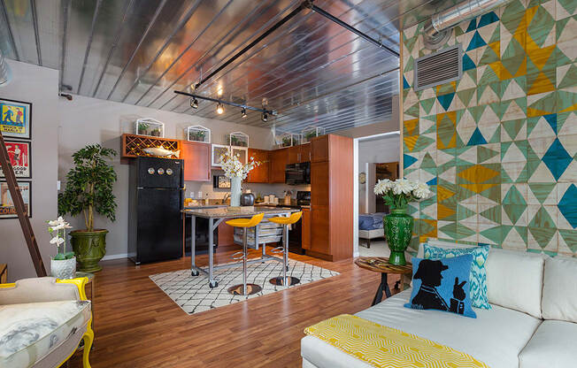 a living room with a kitchen and a yellow couch at Ann Arbor City Club, Ann Arbor Michigan