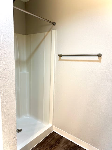 a bathroom with a shower and a towel rack