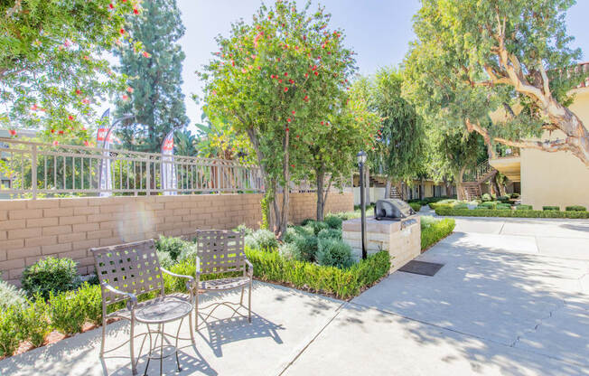 a patio with a table and chairs and a wall and trees