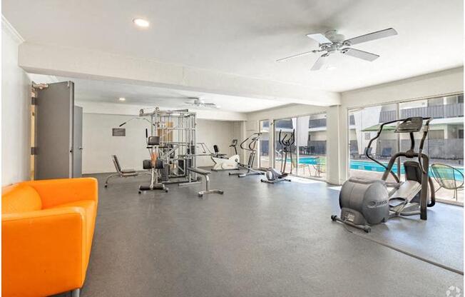 a workout room with a pool and a ceiling fan