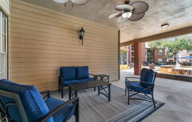 a patio with blue chairs and a ceiling fan