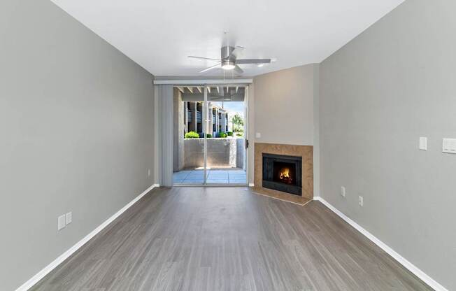 A room with a fireplace and a ceiling fan.