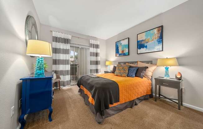 A bedroom with a bed, nightstands, and a chair.