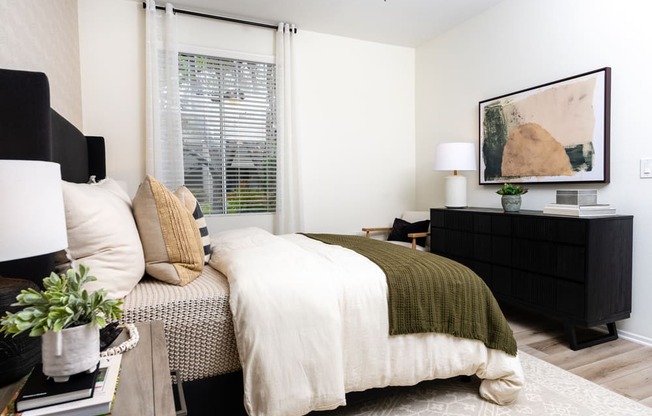 a bedroom with a bed and a dresser and a window