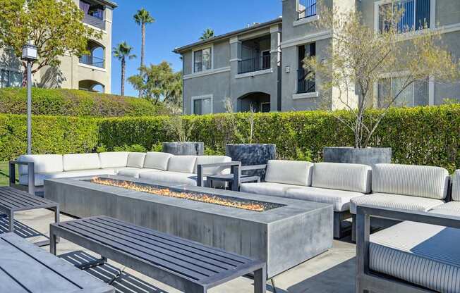 A modern outdoor seating area with a fire pit in the center.
