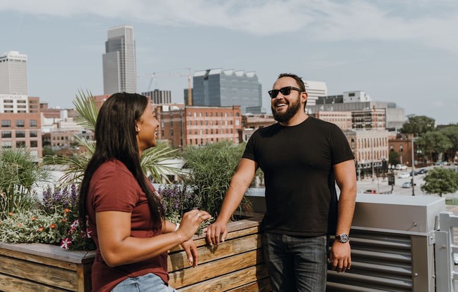 a man and a woman standing on a balcony overlooking the city