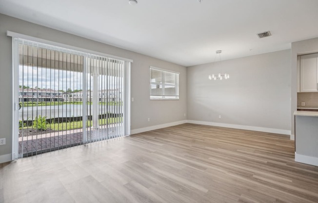 the living room of an apartment with a large window and a sliding glass door