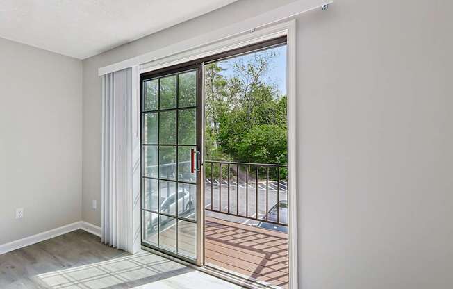 A room with a sliding glass door leading to a balcony.