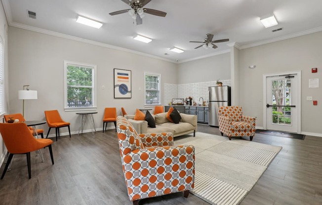 A living room with orange chairs and a patterned sofa.