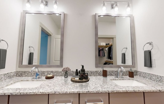 a bathroom with two sinks and two mirrors