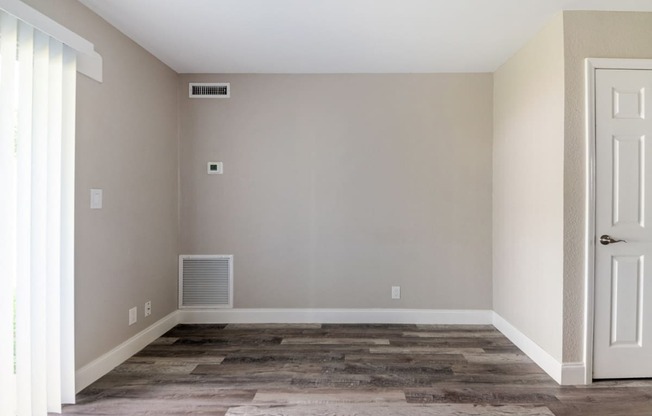 an empty room with wooden floors and a white door