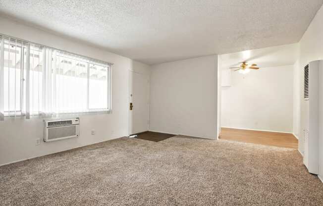 Living room with air conditioning, carpeted flooring , ceiling fan in dining area