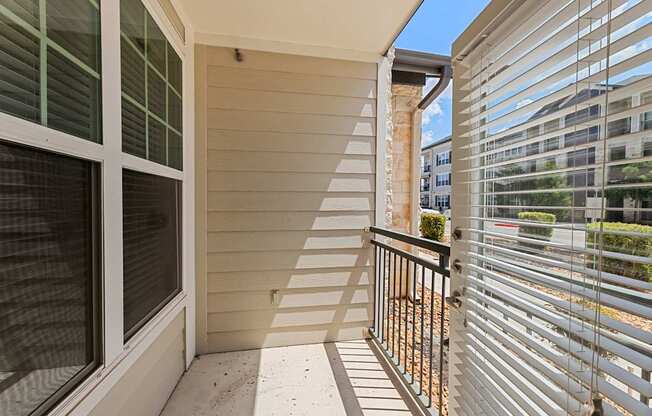 A balcony with a metal railing and a glass door.