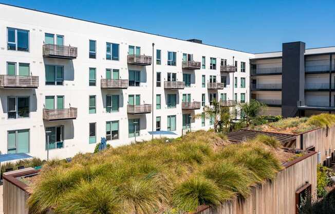 A modern building with a green roof and balconies.