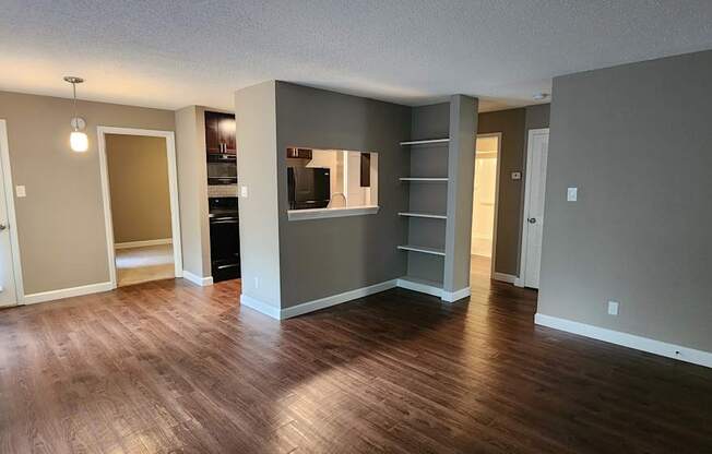 A living room with a grey wall and a wooden floor.