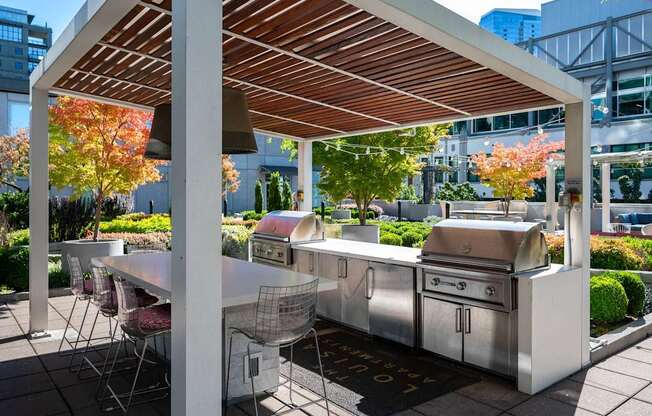 a patio with stainless steel appliances and a table with chairs