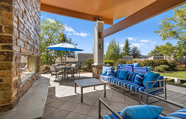 a covered patio with blue chairs and umbrellas