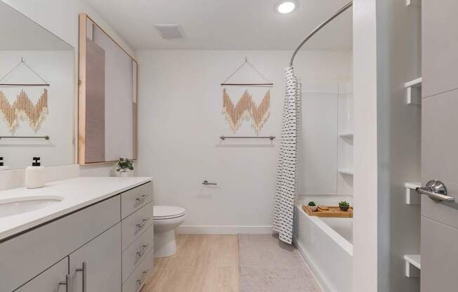 a bathroom with white cabinets and a white toilet and a tub