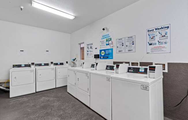 a row of washers and dryers in a laundromat with white machines at Dronfield Astoria, Sylmar, California