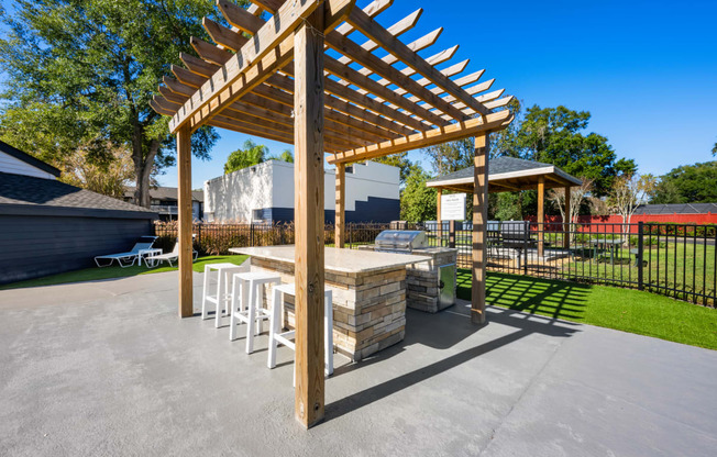 a patio with a picnic table and a grill