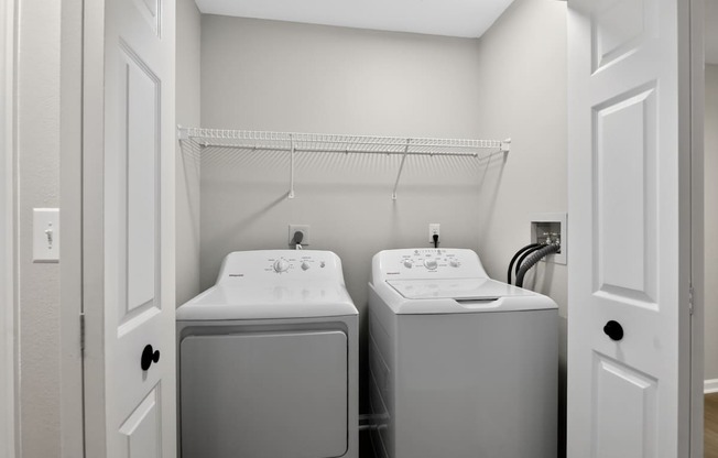 A small bathroom with a sink and a washer and dryer.