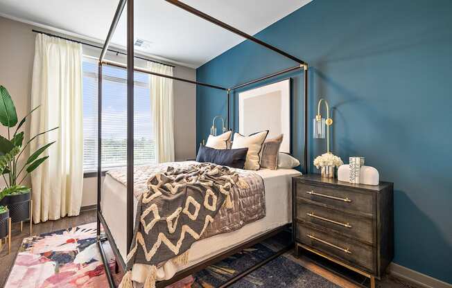 a bedroom with blue walls and a four poster bed at The Griffin Royal Oak, Royal Oak, Michigan