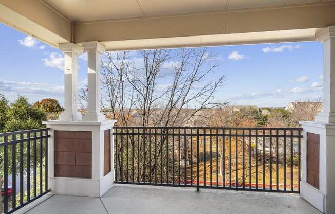 the view from the front porch of a home with a balcony and a fence