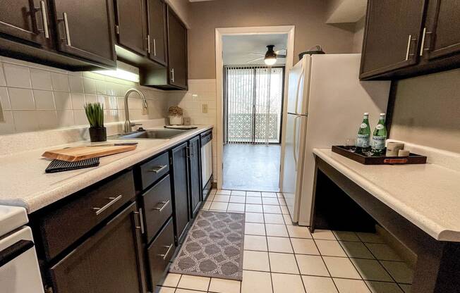 A kitchen with brown cabinets and a white fridge.
