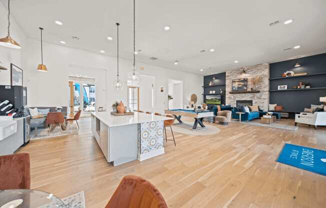 an open living room with a kitchen and dining area and a pool table