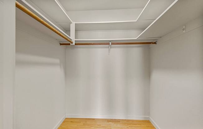 A white room with wooden flooring and white walls.