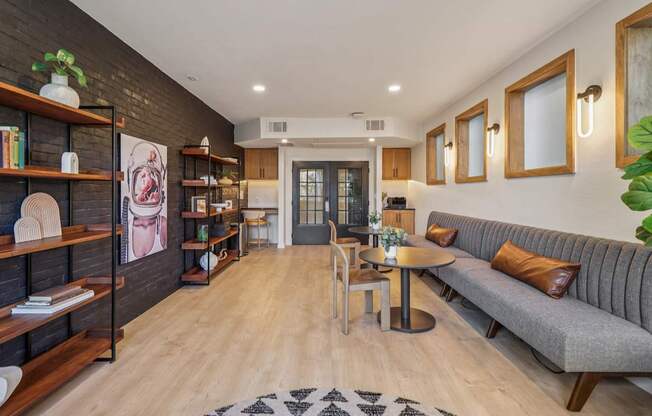 A living room with a grey sofa, a wooden coffee table, and a black and white rug.