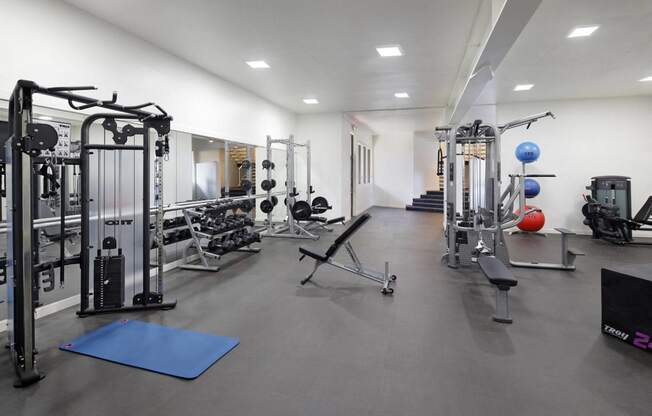 a gym with weights and cardio equipment in a building